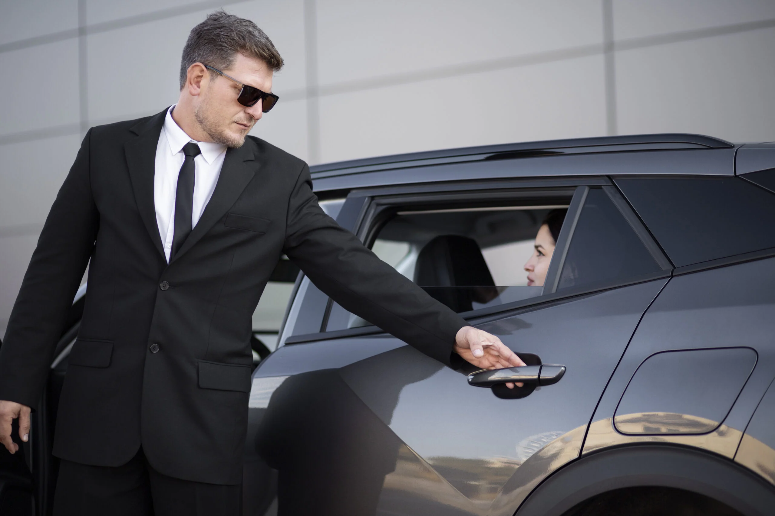 Professional chauffeur opening door for Hamptons Leisure Limo client
